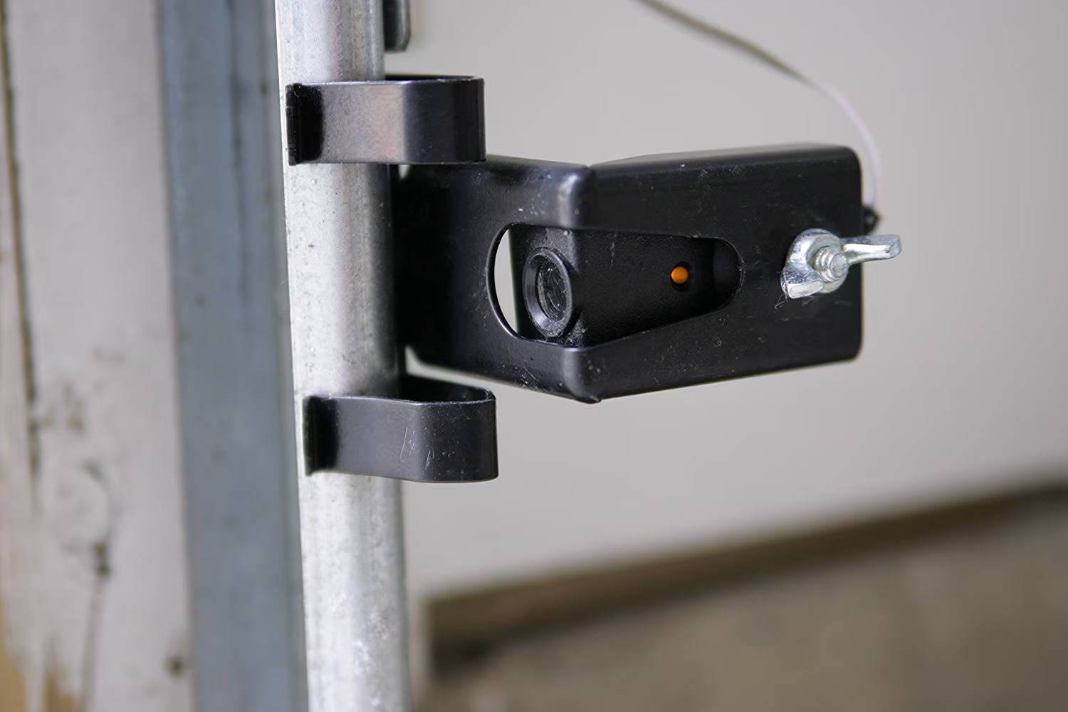 Technician repairing a garage door safety sensor