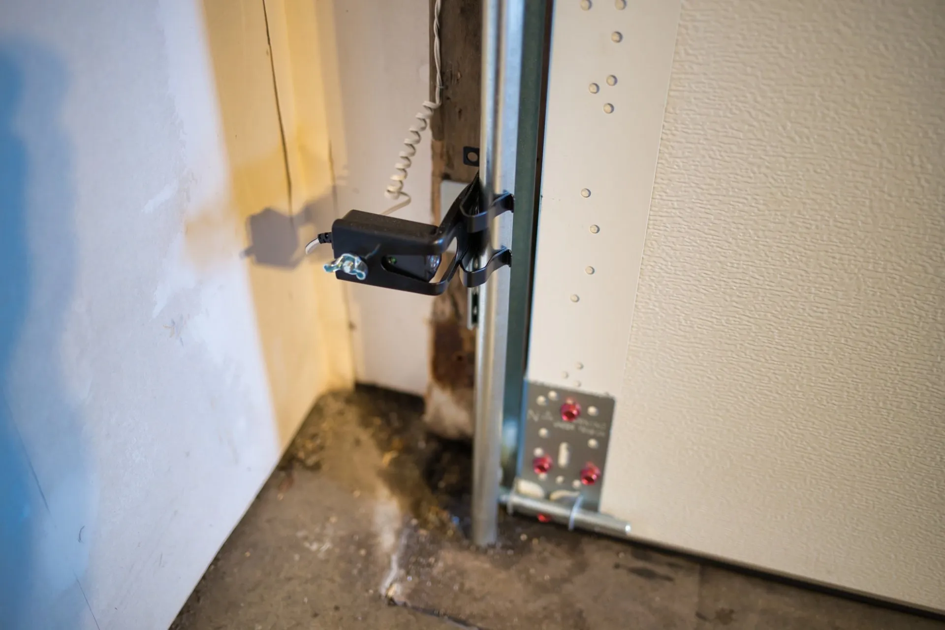 Close-up of a garage door photo eye safety sensor
