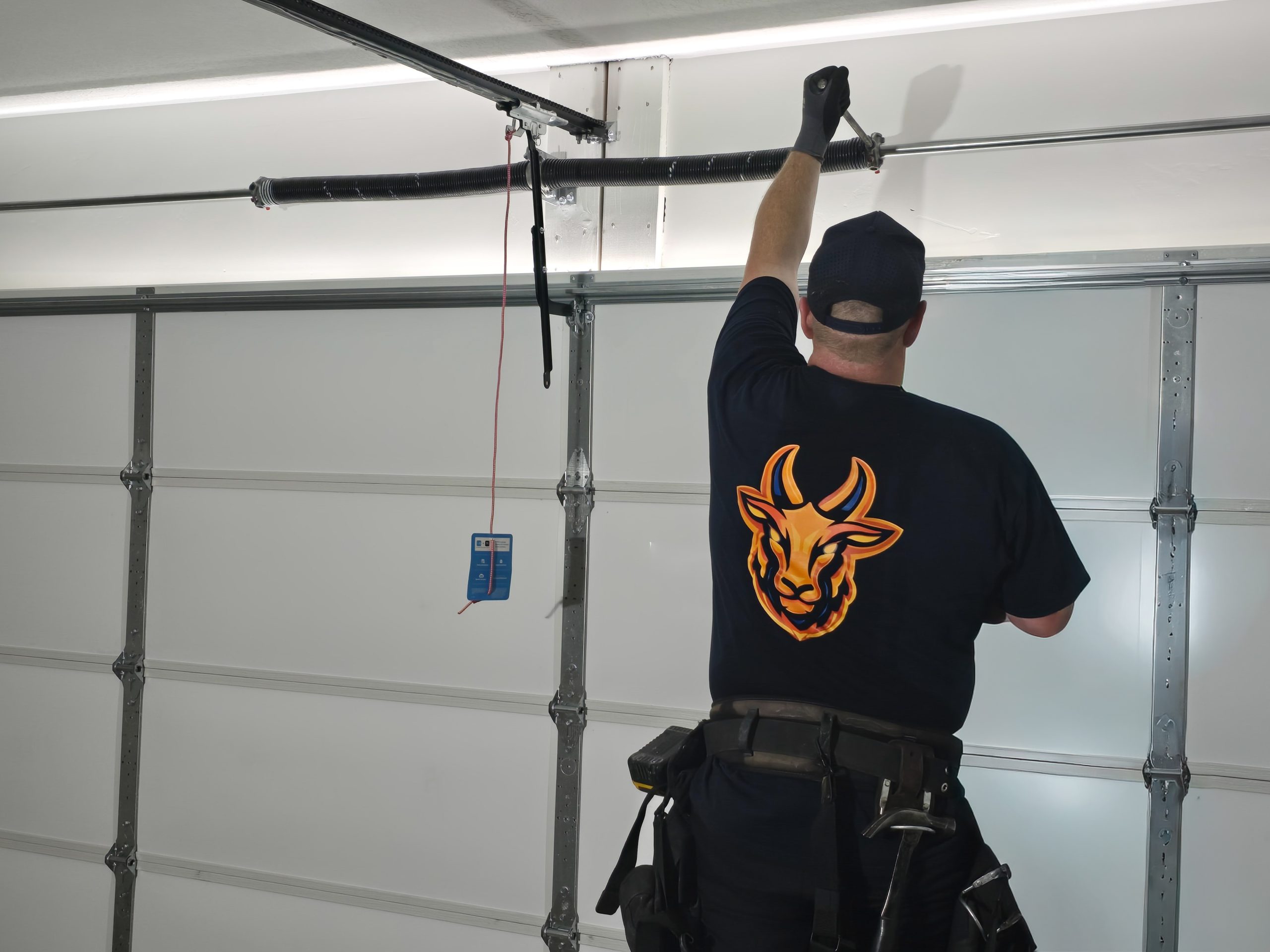 GOAT Garage Doors technician repairing a broken garage door spring in Utah