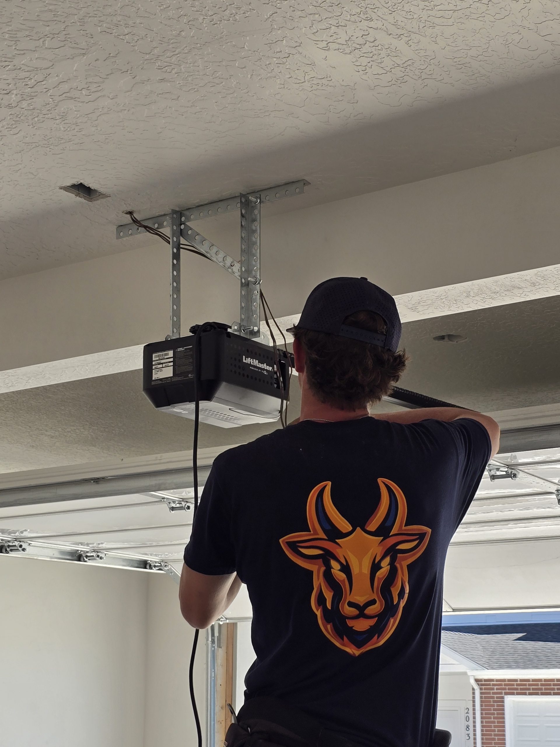 Garage door repair technician working inside a garage