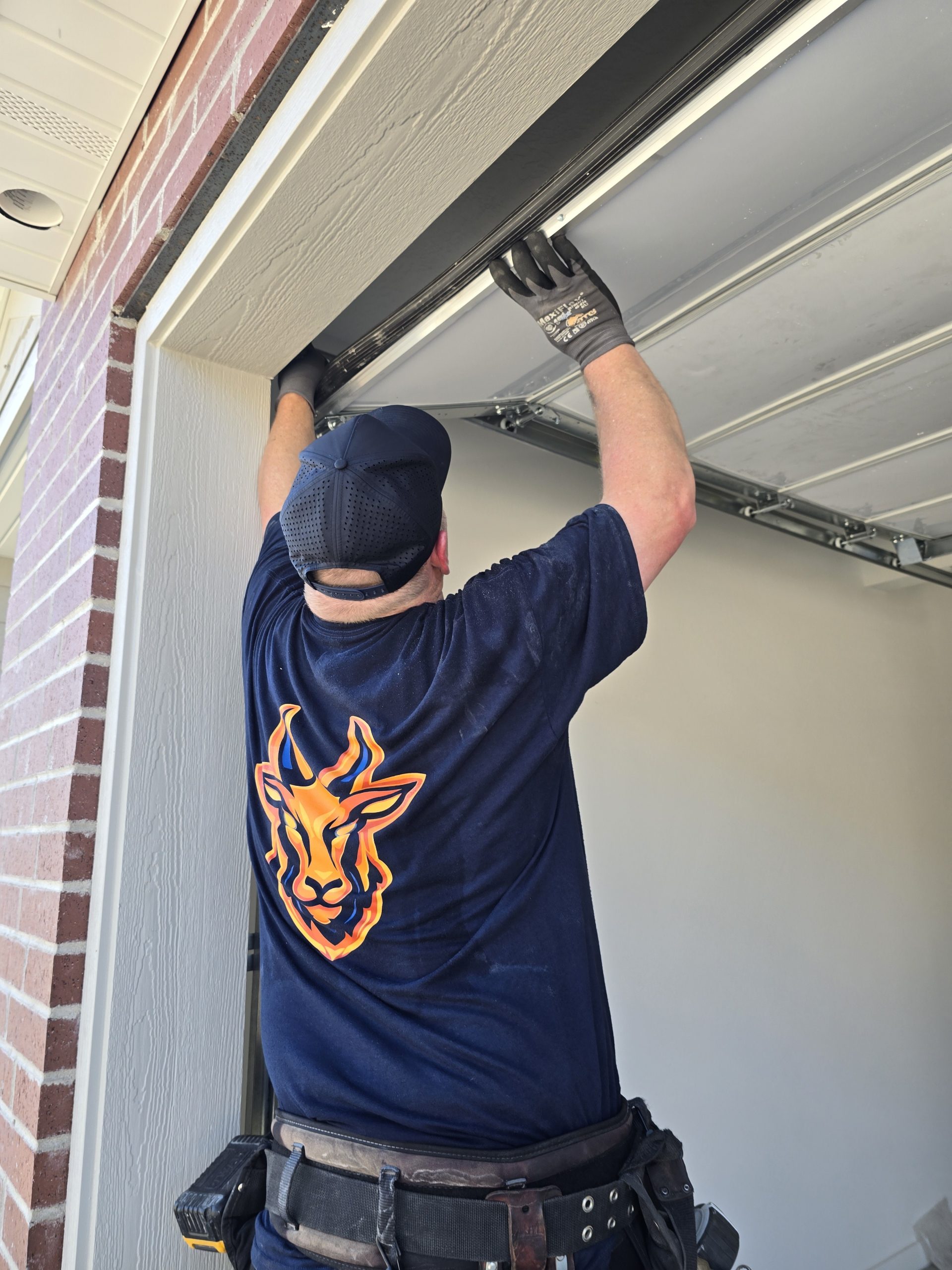 Technician inspecting a garage door that has come off track